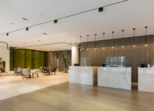 Spacious contemporary lobby with green wall, minimalist seating, and sleek design.