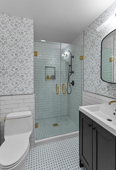 Elegant bathroom design in Austin with glass shower enclosure, patterned floor tiles, and floral wallpaper by Heather Toolin Designs.