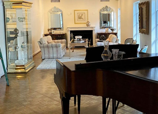 Classical sitting area with vintage decor, large mirrors, and grand piano.