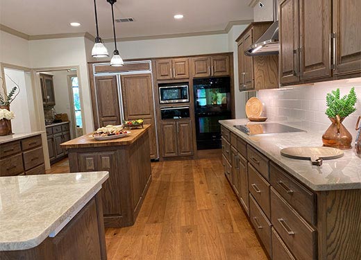 Spacious kitchen with wooden cabinetry, double islands, and ample counter space for cooking and entertaining.